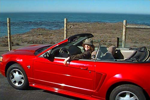 Lara at the beach in her red convertible
